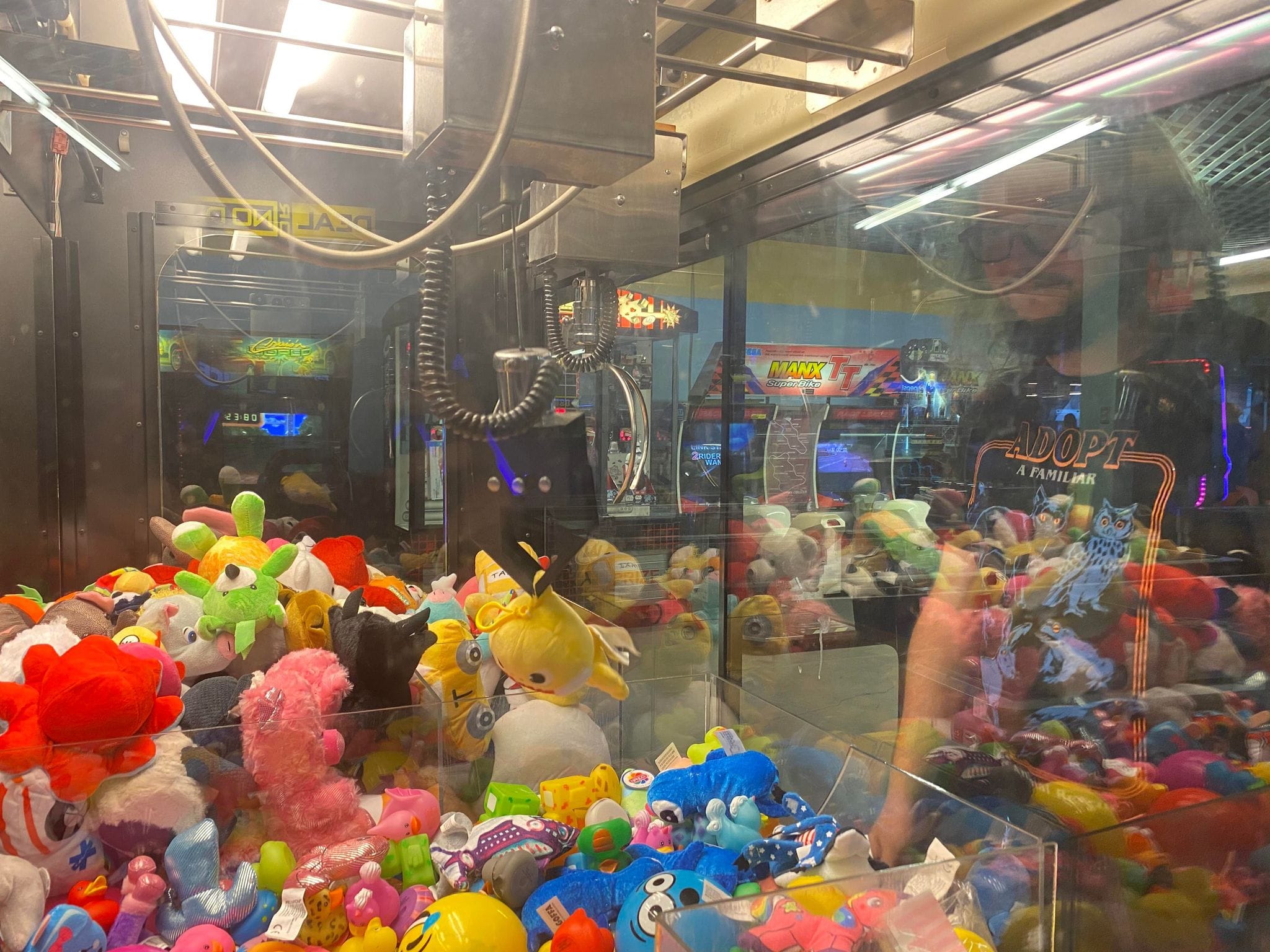 A man with green hair plays an arcade claw game, Photo 2